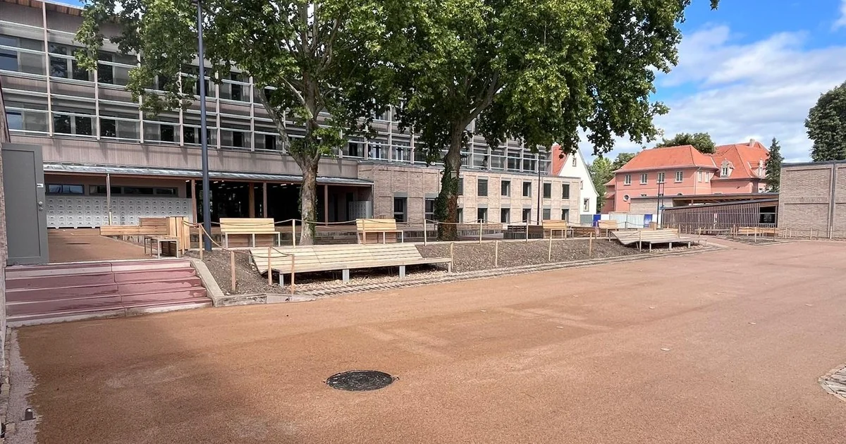 Enrobé drainant posé sur toute la surface de la cour du collège du Neuhof, avec gradins et mobilier bois